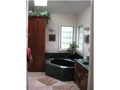Stone flooring, corner window glass and steeping tub, skylight, quality wood vanity, wall sconce lighting, walk in closet, privacy water closet.