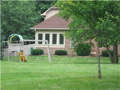 On the s/w corner, year round sunroom captures breeze, lake view, monitor side yard for child's play, all set for creature comfort.