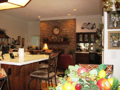 Masonry fireplace is gas log adapted, two sided, includes raised hearth, and flanked by integrated pass thru wet bar. Breakfast bar, hardwood flooring, raised ceiling height, indirect lighting, exit to exterior wood deck and back yard partial fenced