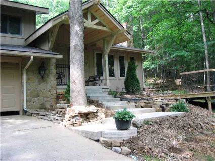 Exterior Front: Landscaped to include front deck, fieldstone retaining walls, entry concrete walk, sandstone walk path, covered entry timber porch. Aesthetically pleasing for plants and people.