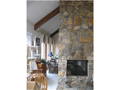 A Vaulted ceiling, sliding glass window wall to exterior deck, gas log fireplace, clearstory transom windows above foyer, all create an open concept with natural light for plants and people.